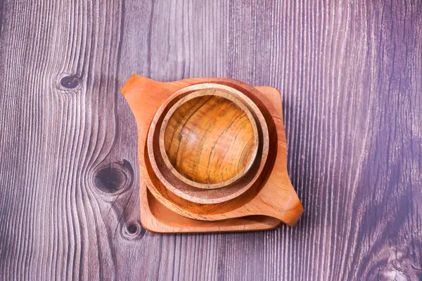 Tahta bir masada kahverengi ahşaptan yapılmış bir kase.