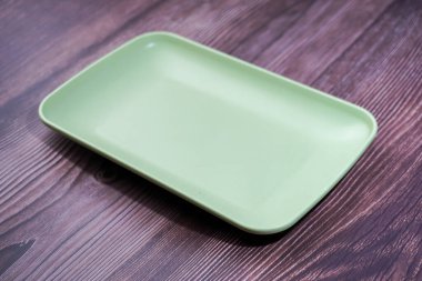 Tahtaya plastikten yapılmış yeşil bir kap yerleştir.