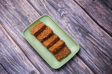 Ahşap bir masada, kabın içinde kızarmış tempeh.