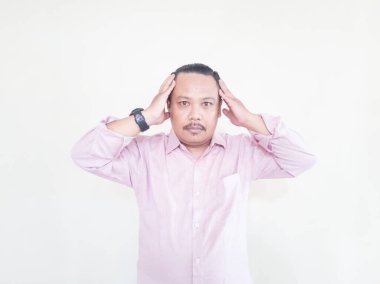 Kahverengi tenli Asyalı bir adam. Pembe gömlekli, beyaz arka planlı.