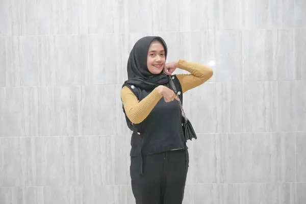 黄色い袖で黒いヒジャブを着ているアジアのインドネシアの女性の表現 — ストック写真
