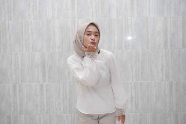 Beyaz gömlek giyen Asyalı Endonezyalı bir kadının gülümsemesi.