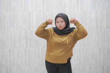 Kahverengi tesettürlü bir kadının mutlu ifadesi.