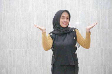 Asyalı Endonezyalı bir kadının sarı kollu siyah bir başörtüsü giymesinin ifadesi
