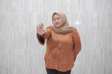 Turuncu gömlek giyen Asyalı Endonezyalı kadının gülümseyen ifadesi