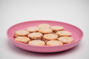 Beyaz bir arka planda bir konteynırda susamlı kurabiye