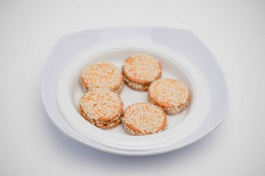 Beyaz bir arka planda bir konteynırda susamlı kurabiye