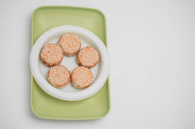 Beyaz bir arka planda bir konteynırda susamlı kurabiye