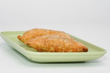 Pazar atıştırmalığına pastel kek deniyor. Beyaz arka planlı bir kabın içinde.