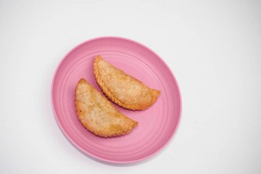 Pazar atıştırmalığına pastel kek deniyor. Beyaz arka planlı bir kabın içinde.