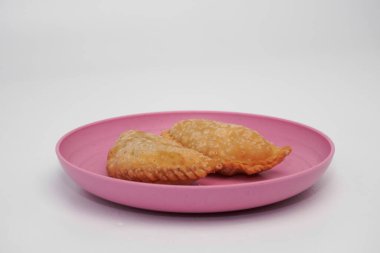 Pazar atıştırmalığına pastel kek deniyor. Beyaz arka planlı bir kabın içinde.