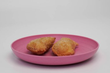 Pazar atıştırmalığına pastel kek deniyor. Beyaz arka planlı bir kabın içinde.