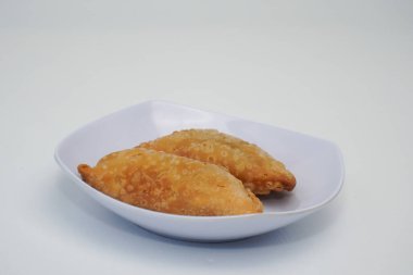 Pazar atıştırmalığına pastel kek deniyor. Beyaz arka planlı bir kabın içinde.