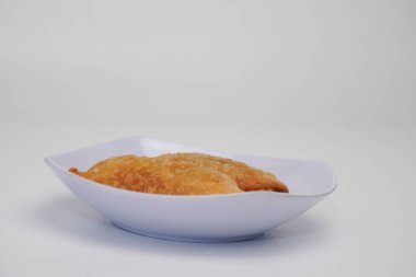 Pazar atıştırmalığına pastel kek deniyor. Beyaz arka planlı bir kabın içinde.