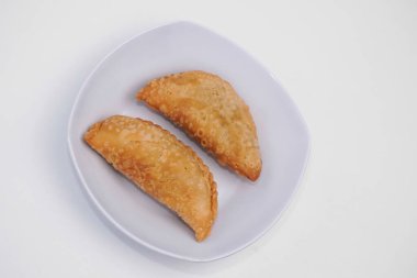 Pazar atıştırmalığına pastel kek deniyor. Beyaz arka planlı bir kabın içinde.