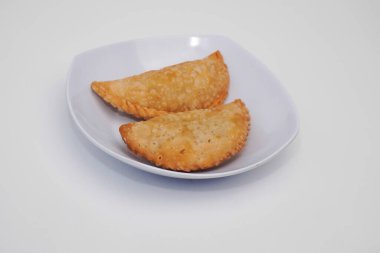 Pazar atıştırmalığına pastel kek deniyor. Beyaz arka planlı bir kabın içinde.