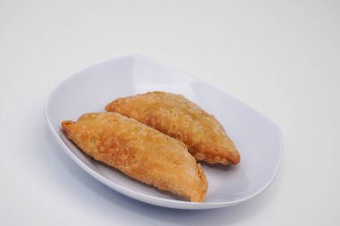 Pazar atıştırmalığına pastel kek deniyor. Beyaz arka planlı bir kabın içinde.