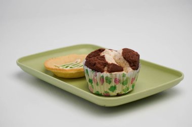 Endonezya 'dan gelen pazar atıştırmalıklarına süt turtası ve çikolatalı sünger keki denir.