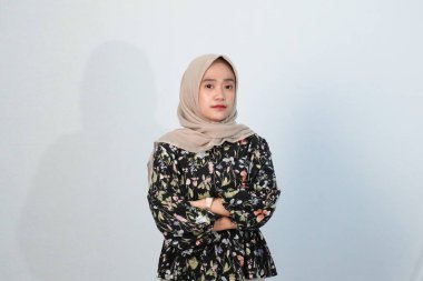 Asyalı Endonezyalı bir kadının tesettürlü, çiçekli siyah bir elbise giymesinin mutlu ifadesi.