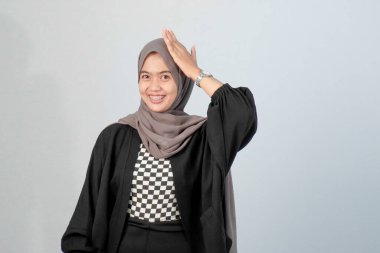 Siyah ve beyaz çeklerle harmanlanmış Endonezyalı Asyalı Müslüman bir kadının portresi.