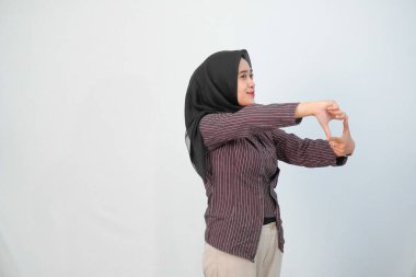 Endonezyalı tesettürlü kadın kahverengi çizgili gömlek giyiyor, tipik Jogja kıyafeti.