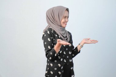 Endonezyalı kadınlar başörtüsü takıyor. Geleneksel Cava kıyafetleri giyiyorlar. Siyah ve beyaz çiçek motifleri var.