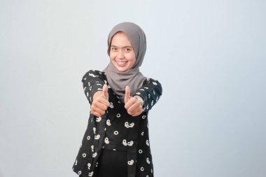 Endonezyalı kadınlar başörtüsü takıyor. Geleneksel Cava kıyafetleri giyiyorlar. Siyah ve beyaz çiçek motifleri var.