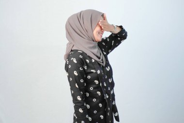 Endonezyalı kadınlar başörtüsü takıyor. Geleneksel Cava kıyafetleri giyiyorlar. Siyah ve beyaz çiçek motifleri var.