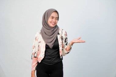 Endonezyalı kadın tesettür giyiyor beyaz elbiseler giyiyor ve renk kombinasyonu yapıyor.