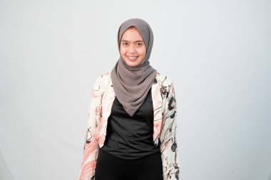 Endonezyalı kadın tesettür giyiyor beyaz elbiseler giyiyor ve renk kombinasyonu yapıyor.