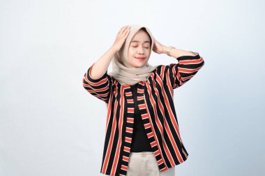 Endonezyalı Asyalı tesettürlü kadınların kahverengi çizgili elbiseleri ve diğer renklerin birleşimi