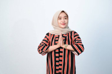 Endonezyalı Asyalı tesettürlü kadınların kahverengi çizgili elbiseleri ve diğer renklerin birleşimi