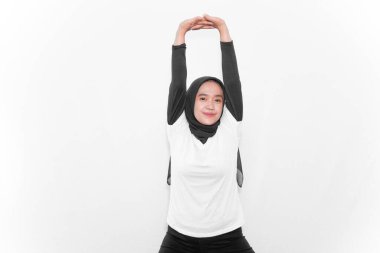 Beyaz elbiseler giyen, iki elini de dik tutan kadınların jimnastik hareketleri.