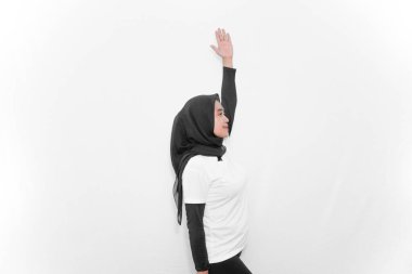 Beyaz elbiseler giyen kadınların jimnastik hareketleri bir elini kaldırıp göğsüne baskı yapıyor.