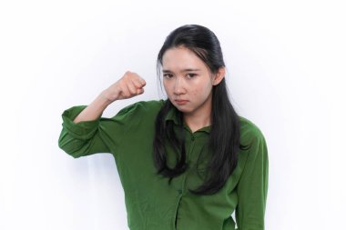 Yeşil giyen Endonezyalı bir Asyalı kadının ifadesi kızgın bir ifade sergiliyor.