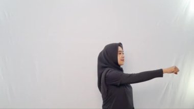 Siyah tesettürlü bir kadın tarafından yapılan ısınma hareketleri.
