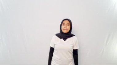 Başörtüsü ve beyaz elbiseler giyen kadınların yaptığı ısınma hareketleri.