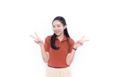 Asya Endonezya modeli turuncu kıyafetler giyerek barış işareti yapıyor.