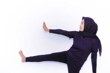 Siyah elbiseli Asyalı kadınlar jimnastik hareketleri sergiliyor.