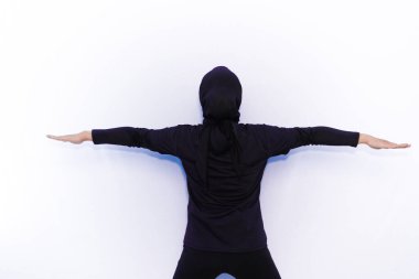 Siyah elbiseli Asyalı kadınlar jimnastik hareketleri sergiliyor.