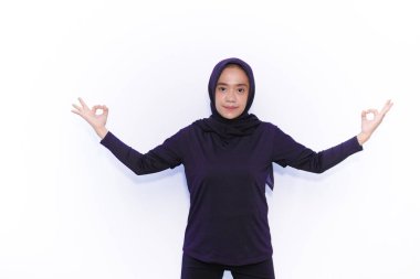 Siyah elbiseli Asyalı kadınlar jimnastik hareketleri sergiliyor.