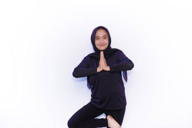 Siyah elbiseli Asyalı kadınlar jimnastik hareketleri sergiliyor.