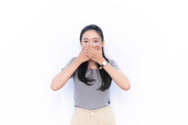 Gri elbiseli Endonezyalı kadın ağzını kapatıyor.