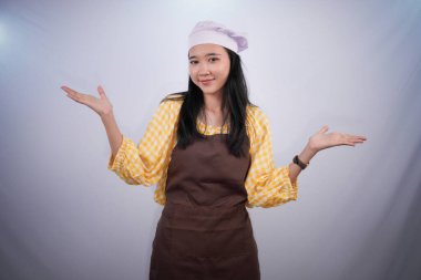 Aşçı üniformalı Asyalı kadın gülümser ve kollarını açar.