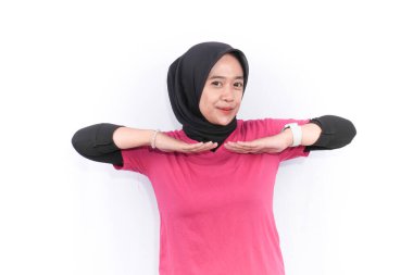 Endonezyalı kadın tesettürlü kırmızı elbise giyiyor ısınma egzersizleri yapıyor.
