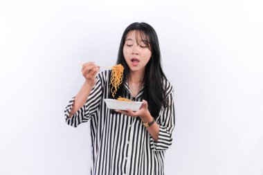 Siyah çizgili Endonezyalı kadın kızarmış eriştenin tadını çıkarıyor.