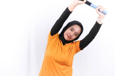 Sarı elbiseli Endonezyalı kadın spor yapıyor.