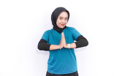 Turkuaz yeşil elbiseli Endonezyalı kadın spor yapıyor.