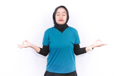 Turkuaz yeşil elbiseli Endonezyalı kadın spor yapıyor.