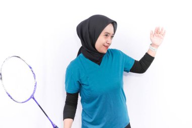 Turkuaz yeşil elbiseli Endonezyalı kadın spor yapıyor.